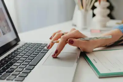 Person Using Laptop on White Table
